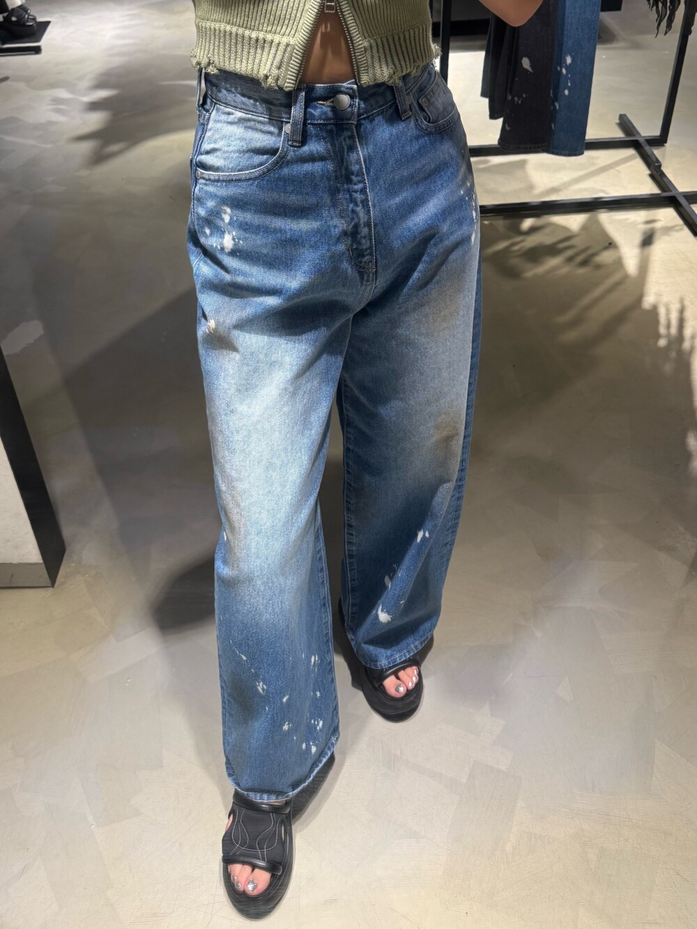 グリーン系のタンクトップ、ブルー系のデニムパンツ、ブラック系のハンドバッグを着用したレディースの夏コーディネートの6枚目の写真