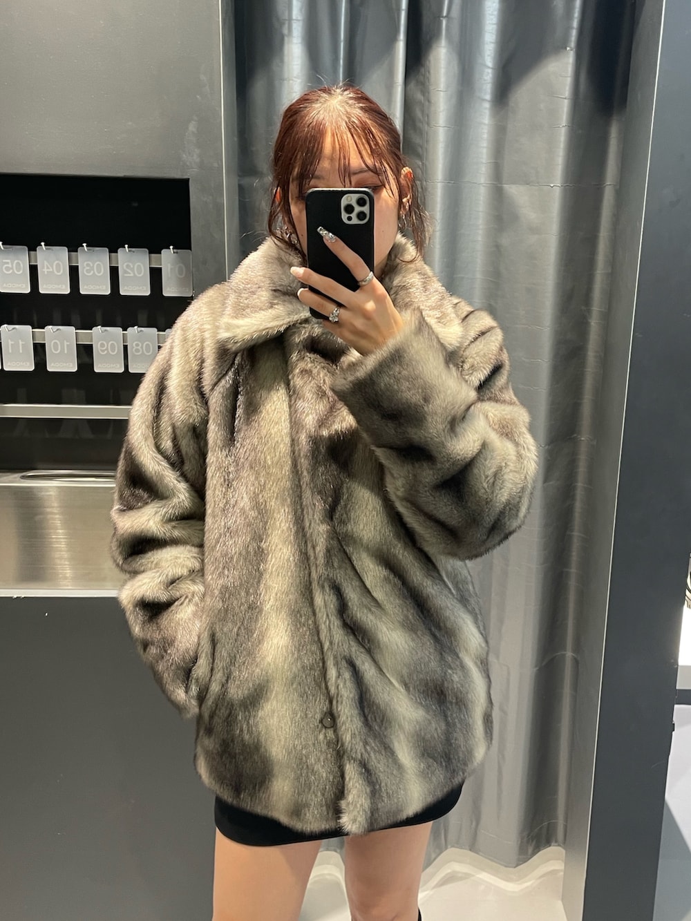 ホワイト系のニット/セーター、グレー系のその他アウター、ブラック系のスカートを着用したレディースの冬コーディネートの4枚目の写真