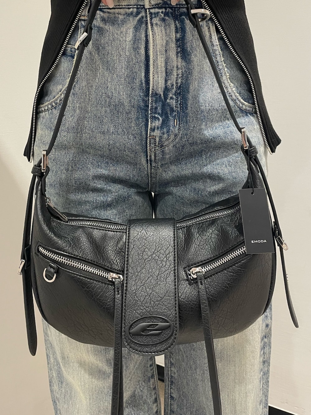 ブラック系のニット/セーター、ブルー系のデニムパンツ、ブラック系のハンドバッグを着用したレディースの冬コーディネートの8枚目の写真