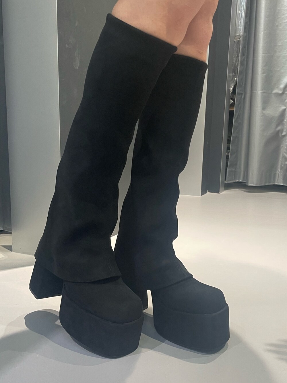 ホワイト系のニット/セーター、グレー系のその他アウター、ブラック系のスカートを着用したレディースの冬コーディネートの9枚目の写真