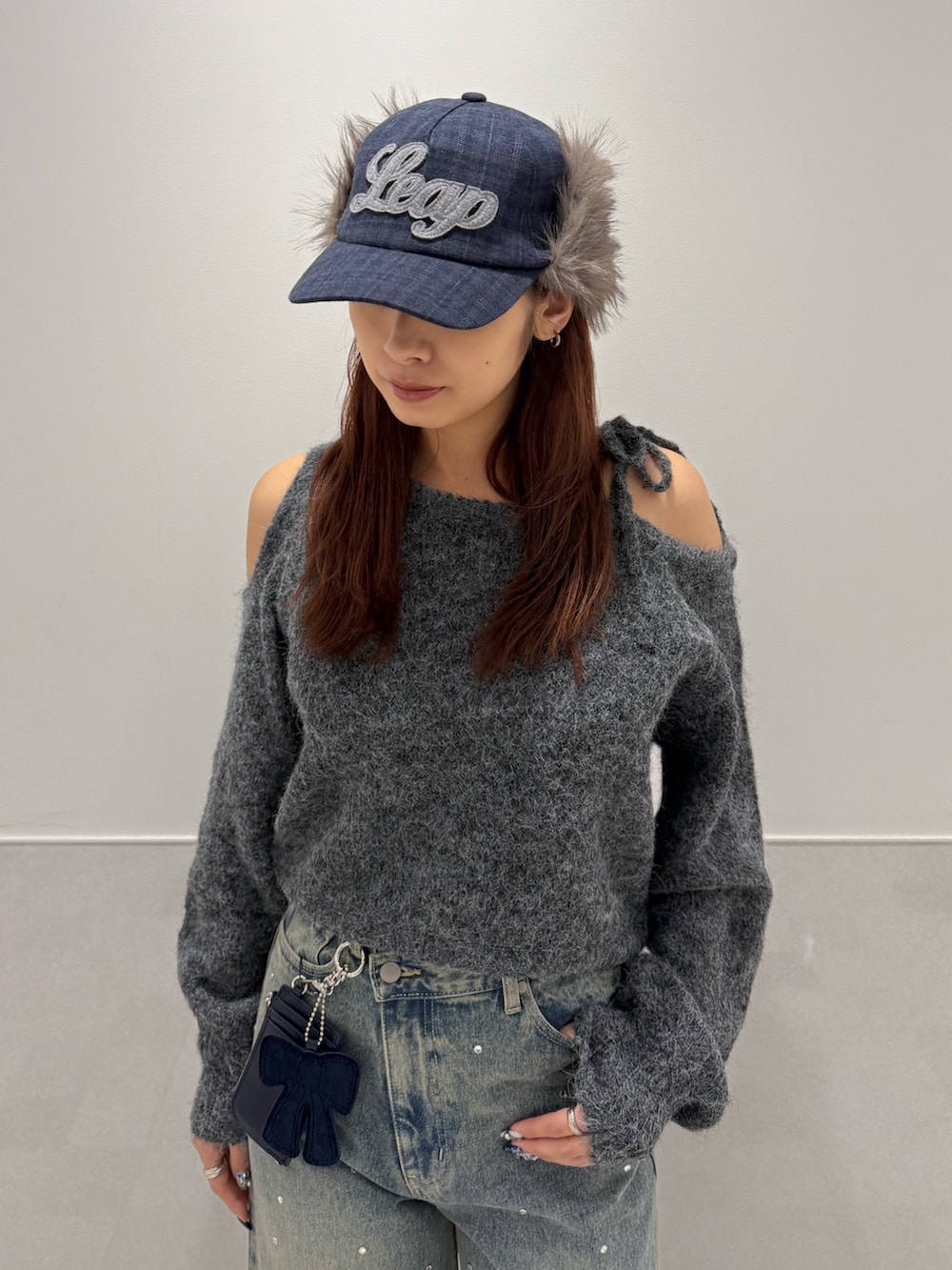 グレー系のニット/セーター、ブラック系のブーツ、ブルー系のデニムパンツを着用したレディースの冬コーディネートの4枚目の写真