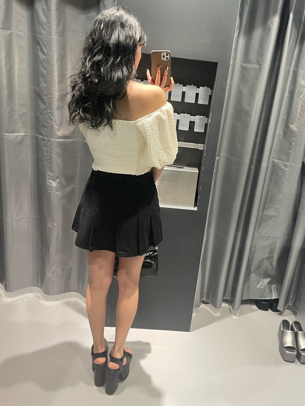 ホワイト系のTシャツ/カットソー、ブラック系のデニムスカート、ブラック系のショルダーバッグを着用したレディースの春コーディネートの3枚目の写真