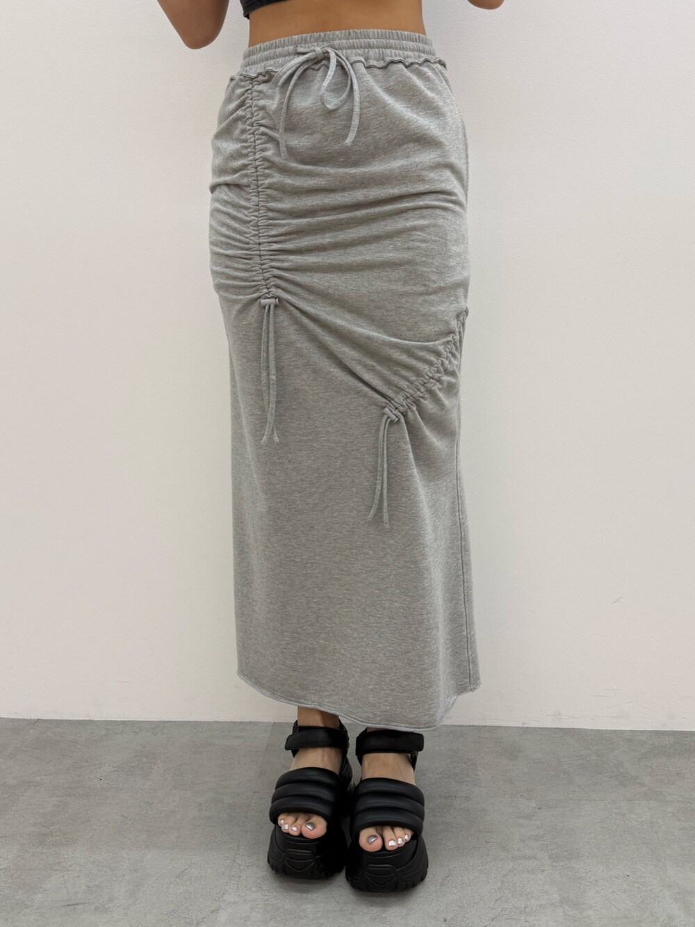 ブラック系のTシャツ/カットソー、グレー系のスカート、ブラック系のサンダルを着用したレディースの夏コーディネートの7枚目の写真