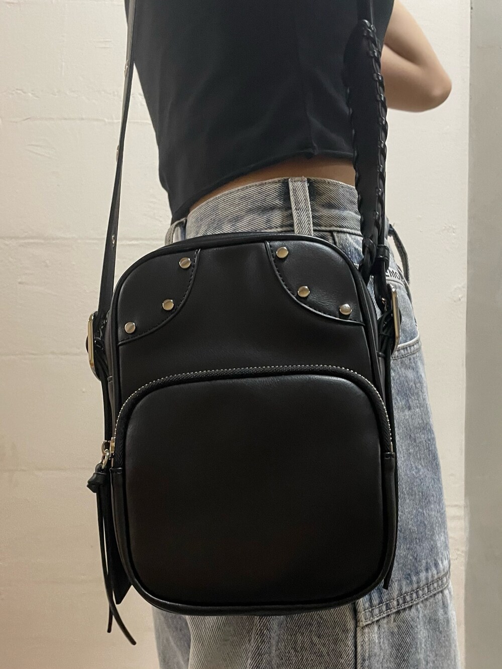 ブラック系のTシャツ/カットソー、ブラック系のショルダーバッグ、ブルー系のデニムパンツを着用したレディースの夏コーディネートの5枚目の写真