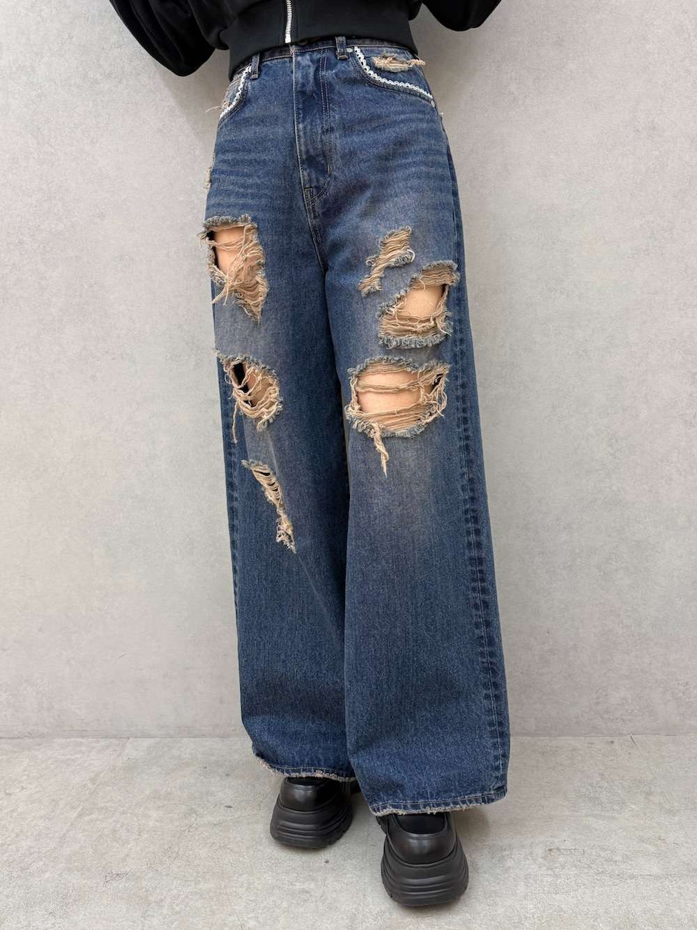 ホワイト系のパーカー、ブルー系のデニムパンツ、ブラック系のパンプスを着用したレディースの冬コーディネートの5枚目の写真