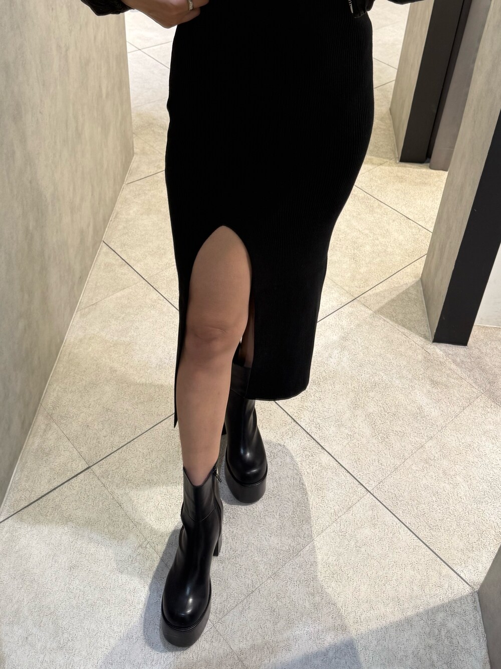 ブラック系のブルゾン、ブラック系のワンピース、ブラック系のブーツを着用したレディースの秋コーディネートの6枚目の写真