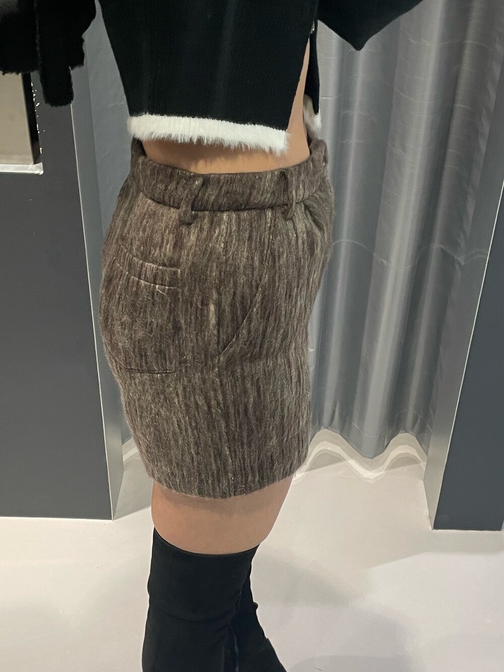 ブラック系のニット/セーター、ブラウン系のその他パンツ、ブラック系のショルダーバッグを着用したレディースの冬コーディネートの7枚目の写真