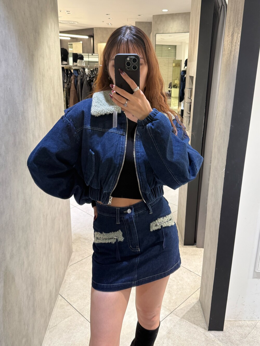 ブルー系のブルゾン、ブラック系のニット/セーター、ブルー系のスカートを着用したレディースの秋コーディネートの4枚目の写真