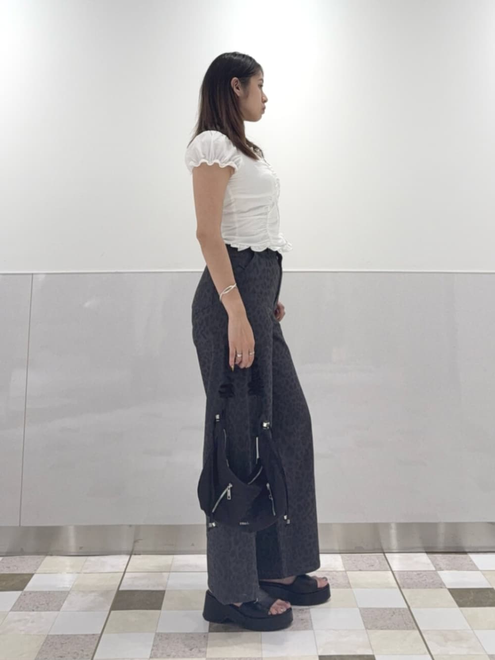 ブラック系のショルダーバッグ、ホワイト系のシャツ/ブラウス、グレー系のその他パンツを着用したレディースの夏コーディネートの2枚目の写真