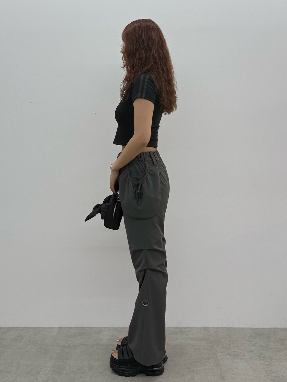 ブラック系のTシャツ/カットソー、グレー系のその他パンツ、ブラック系のハンドバッグを着用したレディースの夏コーディネートの2枚目の写真