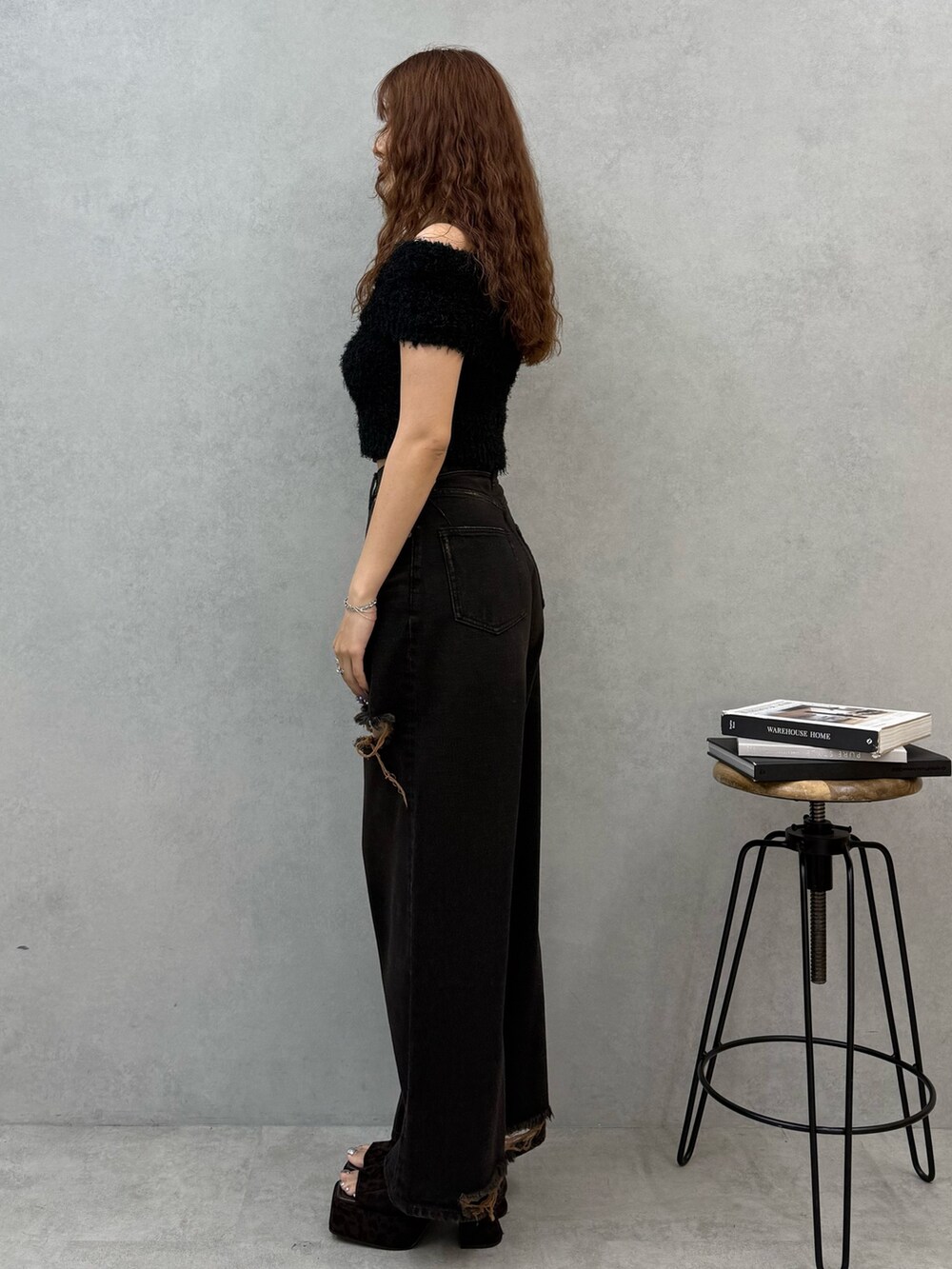 ブラック系のニット/セーター、ブラック系のデニムパンツ、ブラウン系のサンダルを着用したレディースの夏コーディネートの2枚目の写真