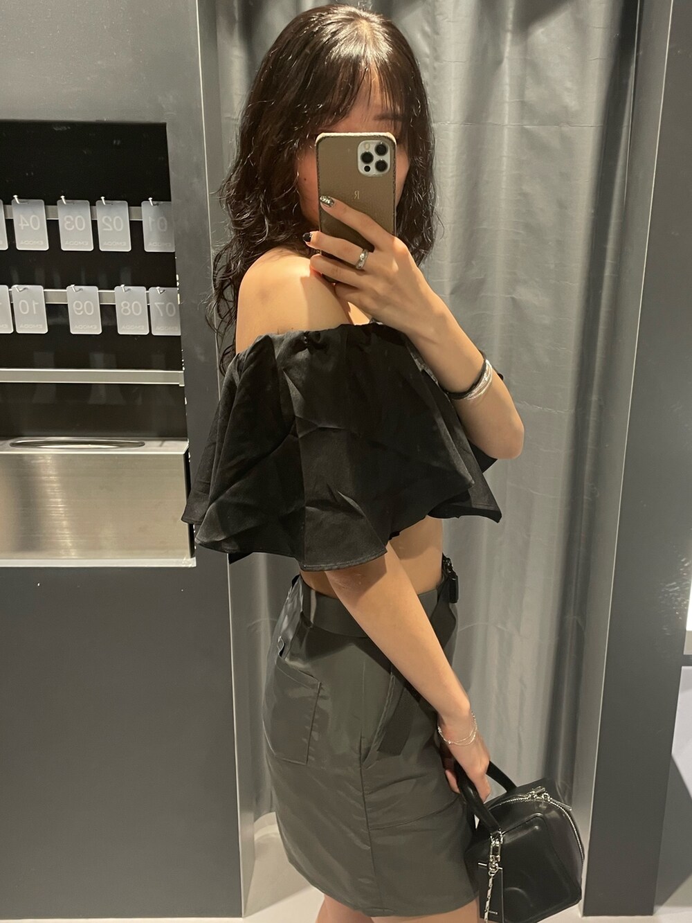 ブラック系のTシャツ/カットソー、ブラック系のハンドバッグ、グレー系のスカートを着用したレディースの夏コーディネートの7枚目の写真