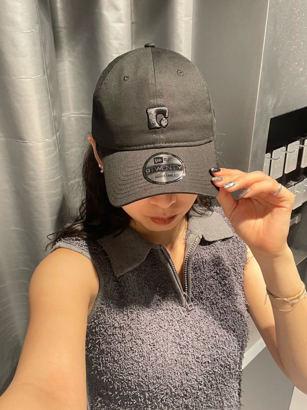 グレー系のタンクトップ、ブラック系のスカート、ブラック系のサンダルを着用したレディースの夏コーディネートの6枚目の写真