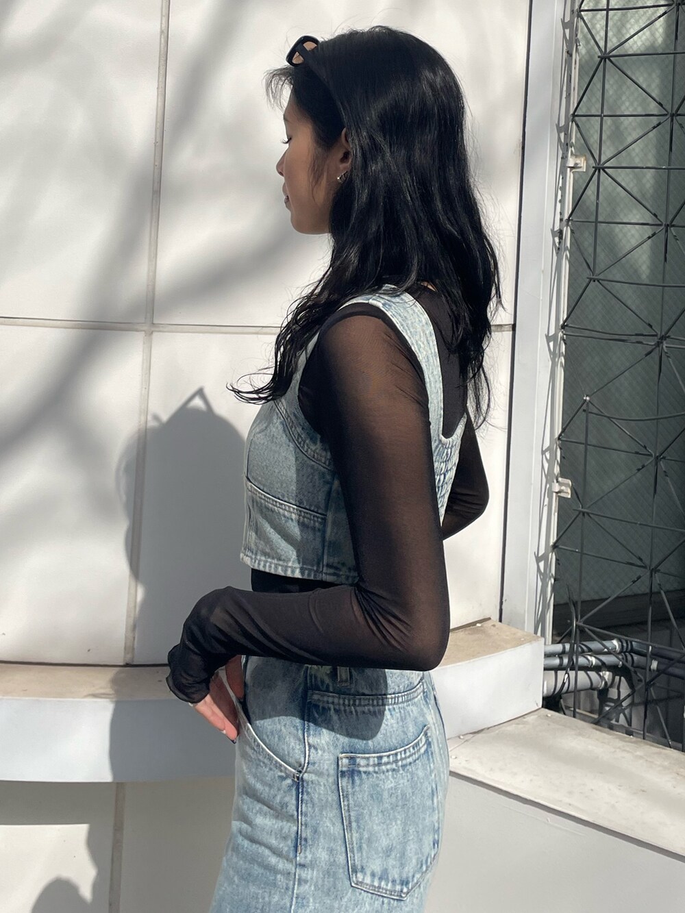 ブラック系のTシャツ/カットソー、ブルー系のキャミソール、ブルー系のデニムパンツを着用したレディースの春コーディネートの5枚目の写真