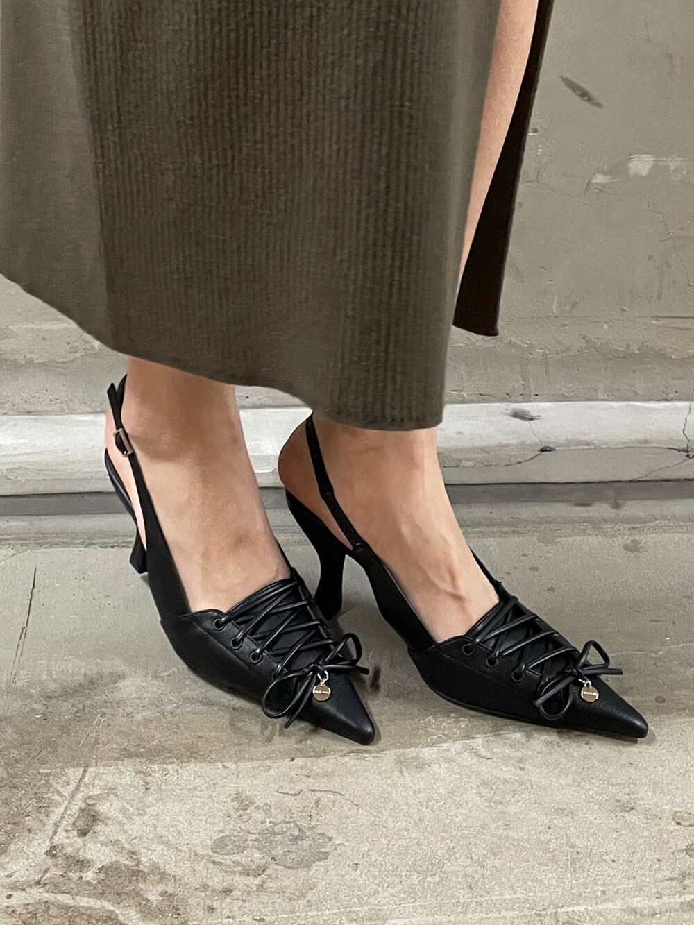 ブラック系のニット/セーター、ブラック系のデニムパンツ、ブラック系のパンプスを着用したレディースの春コーディネートの9枚目の写真