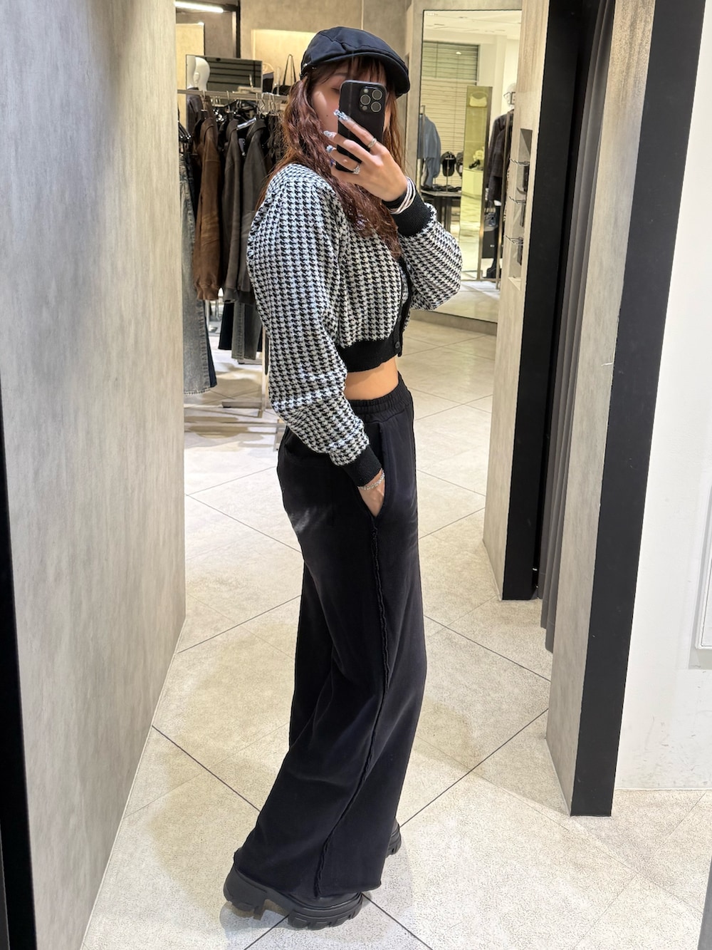 ブラック系のニット/セーター、ブラック系のスウェットパンツ、ブラック系のブーツを着用したレディースの秋コーディネートの2枚目の写真