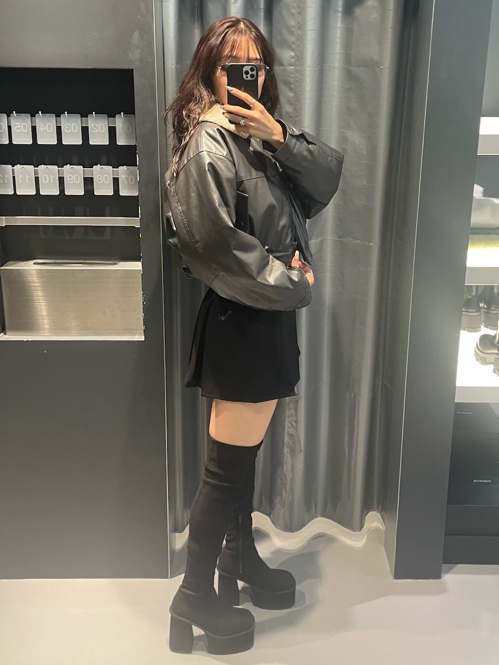 グレー系のブルゾン、ブラック系のTシャツ/カットソー、ブラック系のスカートを着用したレディースの冬コーディネートの2枚目の写真