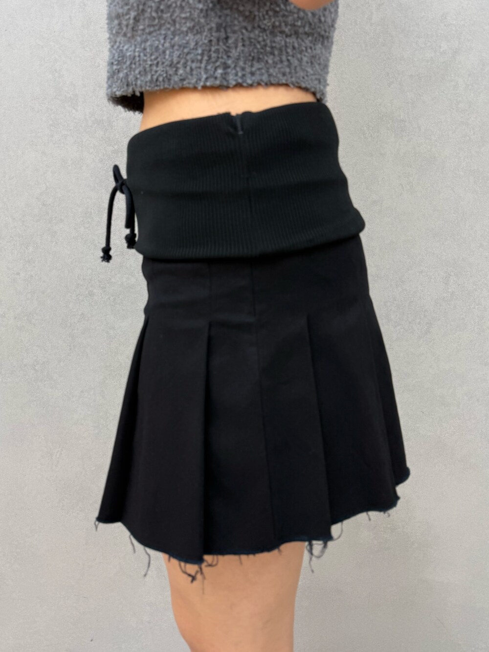 ブラック系のスカート、ブラック系のサンダル、グレー系のニット/セーターを着用したレディースの夏コーディネートの8枚目の写真