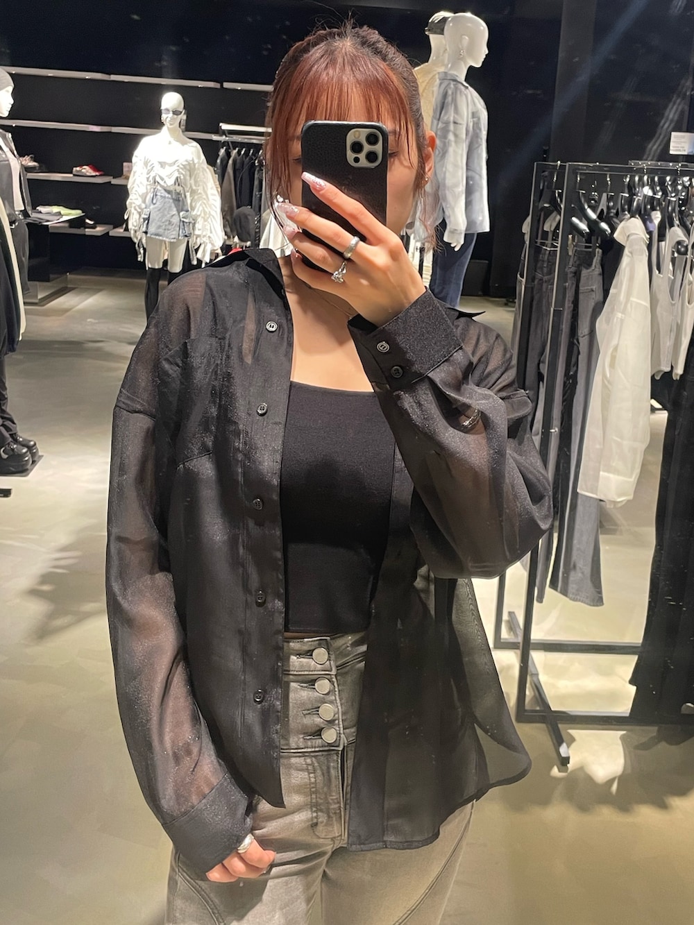 ブラック系のニット/セーター、ブラック系のシャツ/ブラウス、ブラック系のデニムパンツを着用したレディースの春コーディネートの4枚目の写真