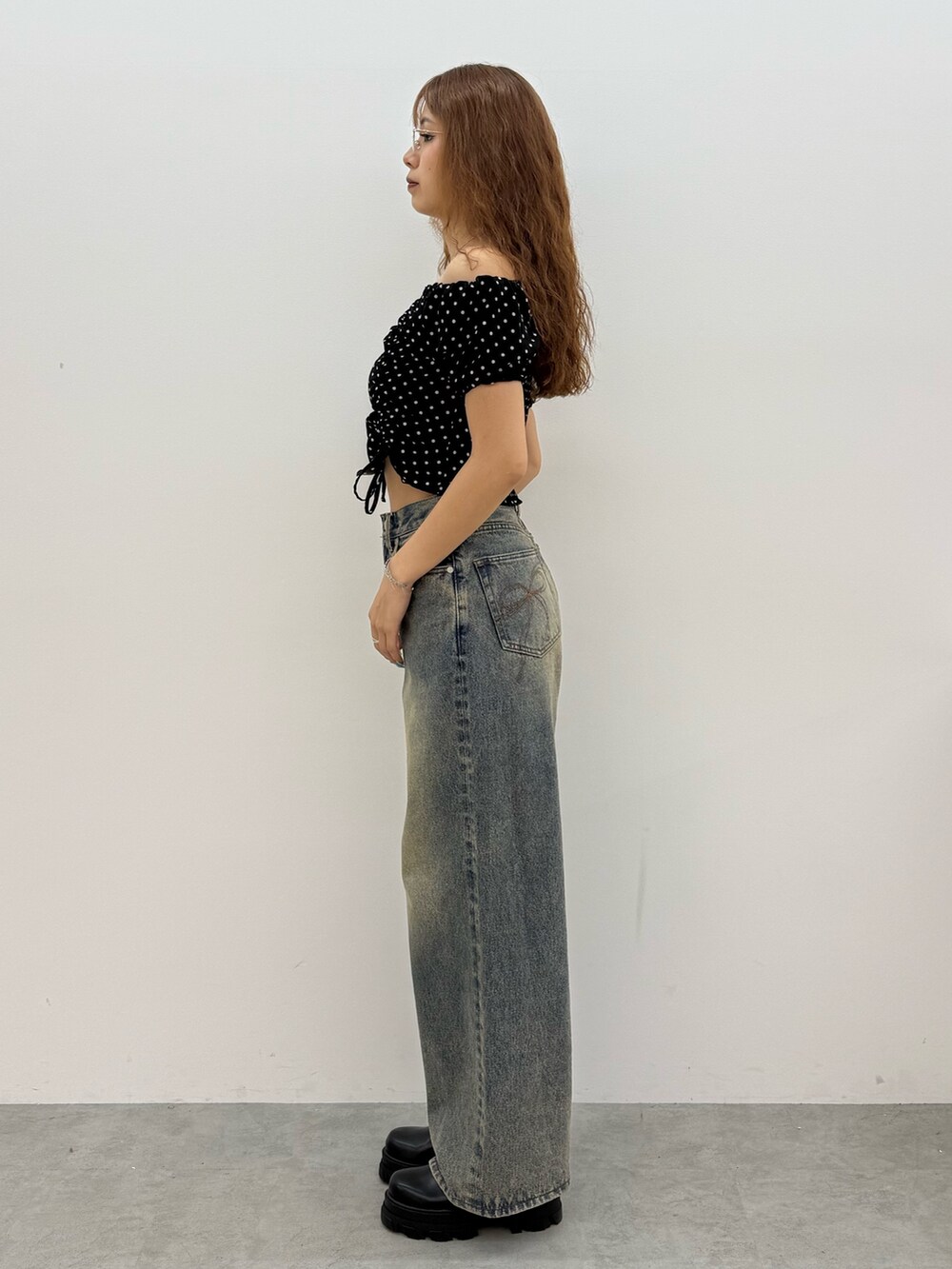 ブラック系のTシャツ/カットソー、ブルー系のデニムパンツ、ブラック系のブーツを着用したレディースの夏コーディネートの2枚目の写真