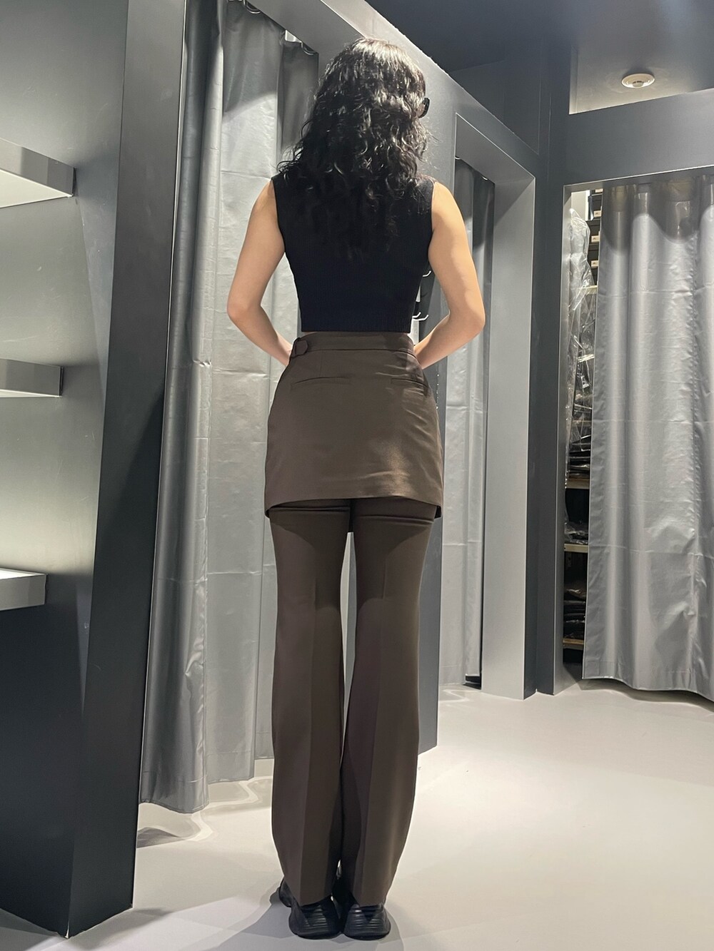 ブラック系のニット/セーター、ブラウン系のその他パンツ、ブラック系のサンダルを着用したレディースの夏コーディネートの3枚目の写真