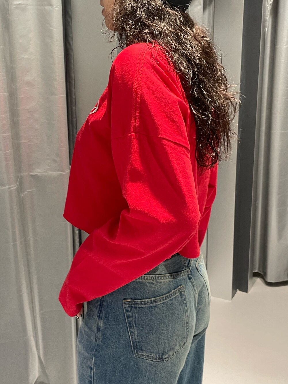 レッド系のTシャツ/カットソー、ブルー系のデニムスカート、その他のブーツを着用したレディースの秋コーディネートの5枚目の写真