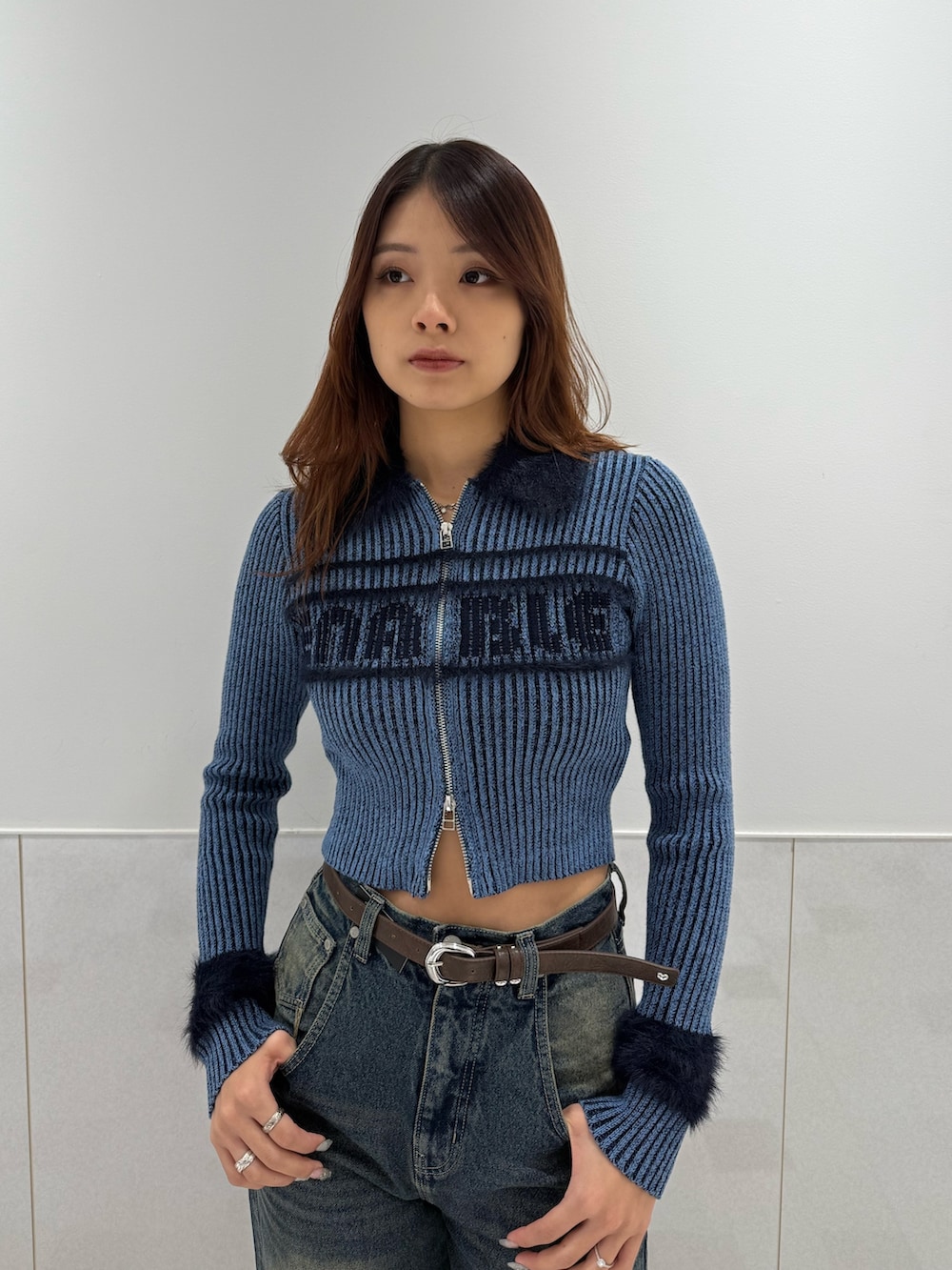 ブルー系のニット/セーター、ブルー系のデニムパンツ、ブラック系のブーツを着用したレディースの冬コーディネートの4枚目の写真