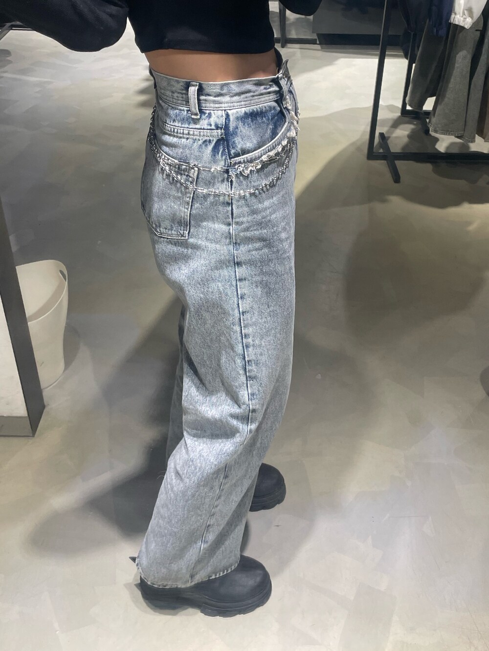 ブラック系のTシャツ/カットソー、ブルー系のデニムパンツ、ブラック系のブーツを着用したレディースの春コーディネートの7枚目の写真