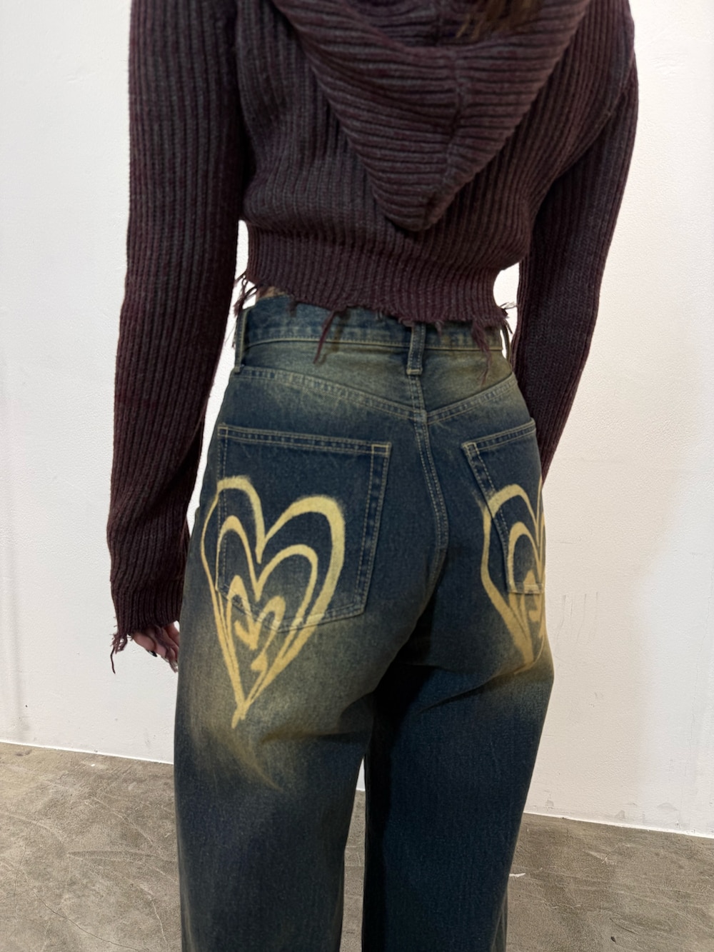 レッド系のニット/セーター、ブルー系のデニムパンツ、ブラック系のブーツを着用したレディースの冬コーディネートの6枚目の写真