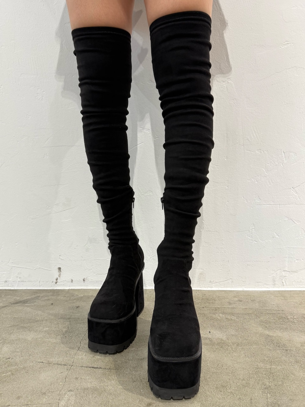 ブラック系のブーツ、グレー系のニット/セーター、ブラック系のスカートを着用したレディースの冬コーディネートの5枚目の写真