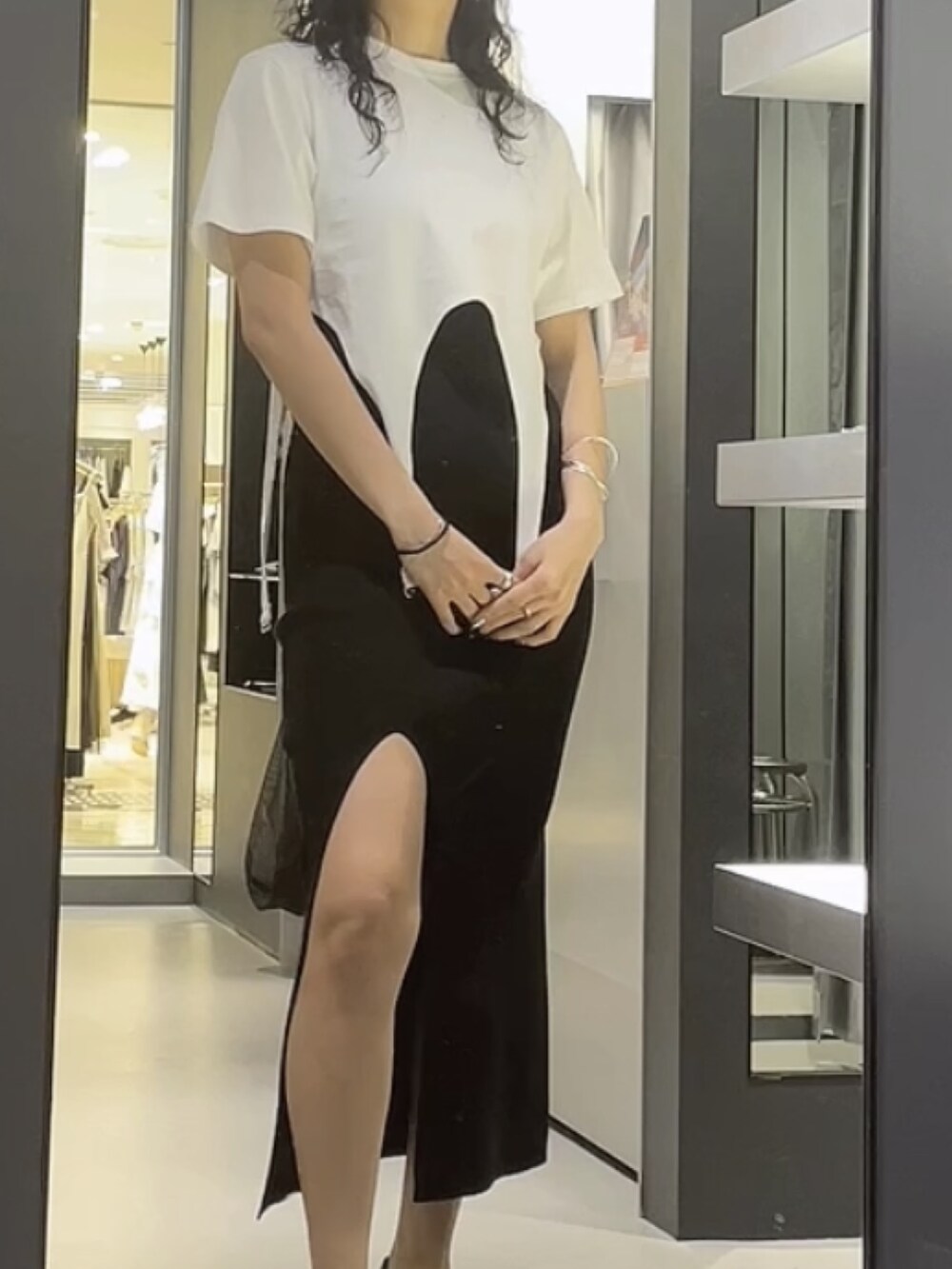 ホワイト系のTシャツ/カットソー、ブラック系のワンピース、ブラック系のサンダルを着用したレディースの夏コーディネートの3枚目の写真