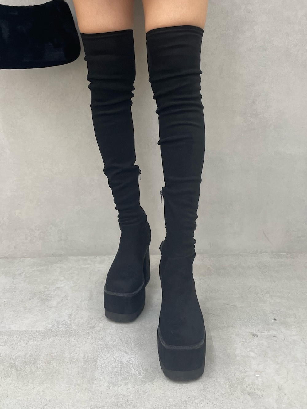 グレー系のニット/セーター、ブラック系のスカート、ブラック系のブーツを着用したレディースの秋コーディネートの8枚目の写真