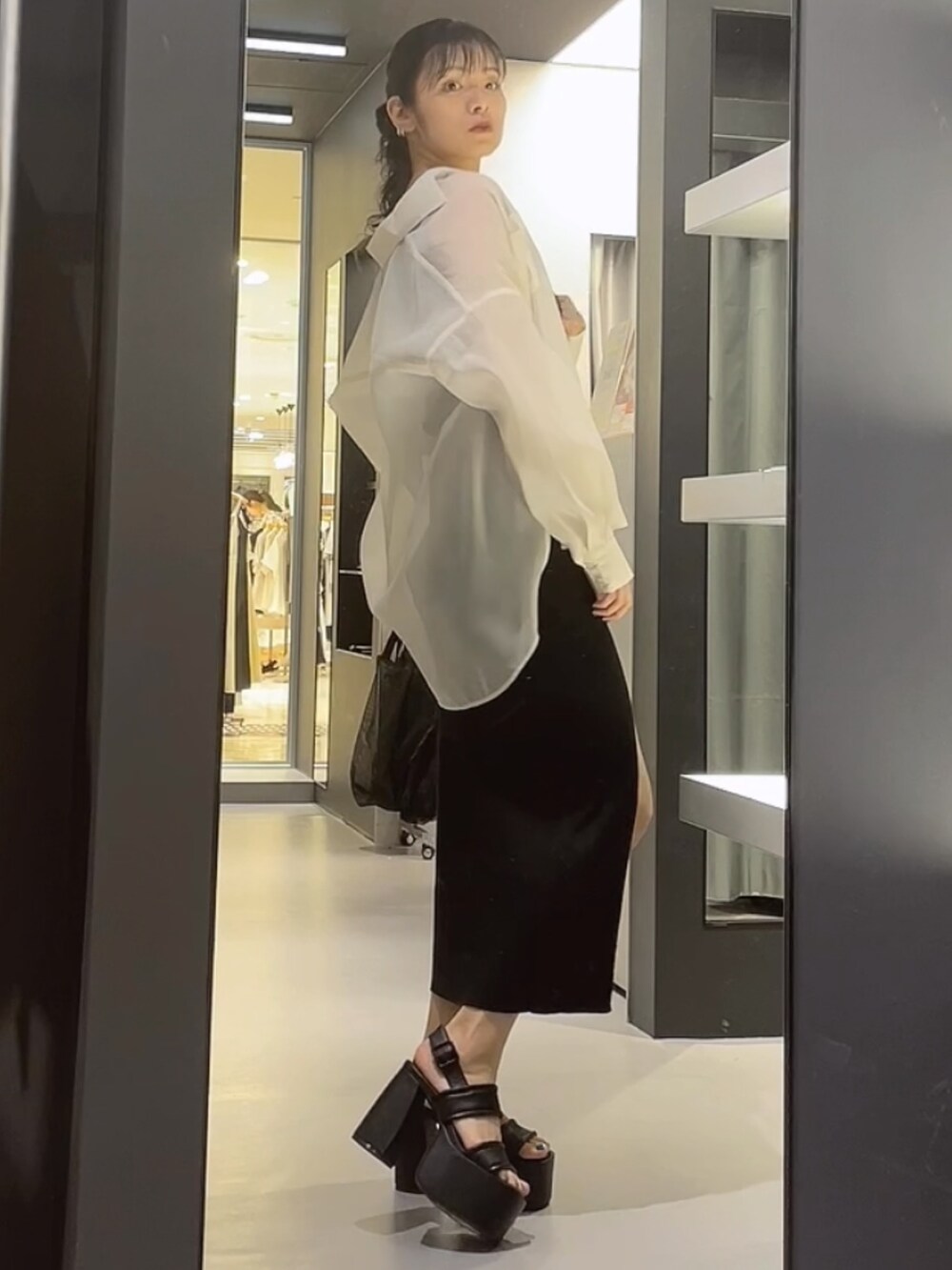 ブラック系のハンドバッグ、ホワイト系のシャツ/ブラウス、ブラック系のワンピースを着用したレディースの夏コーディネートの2枚目の写真