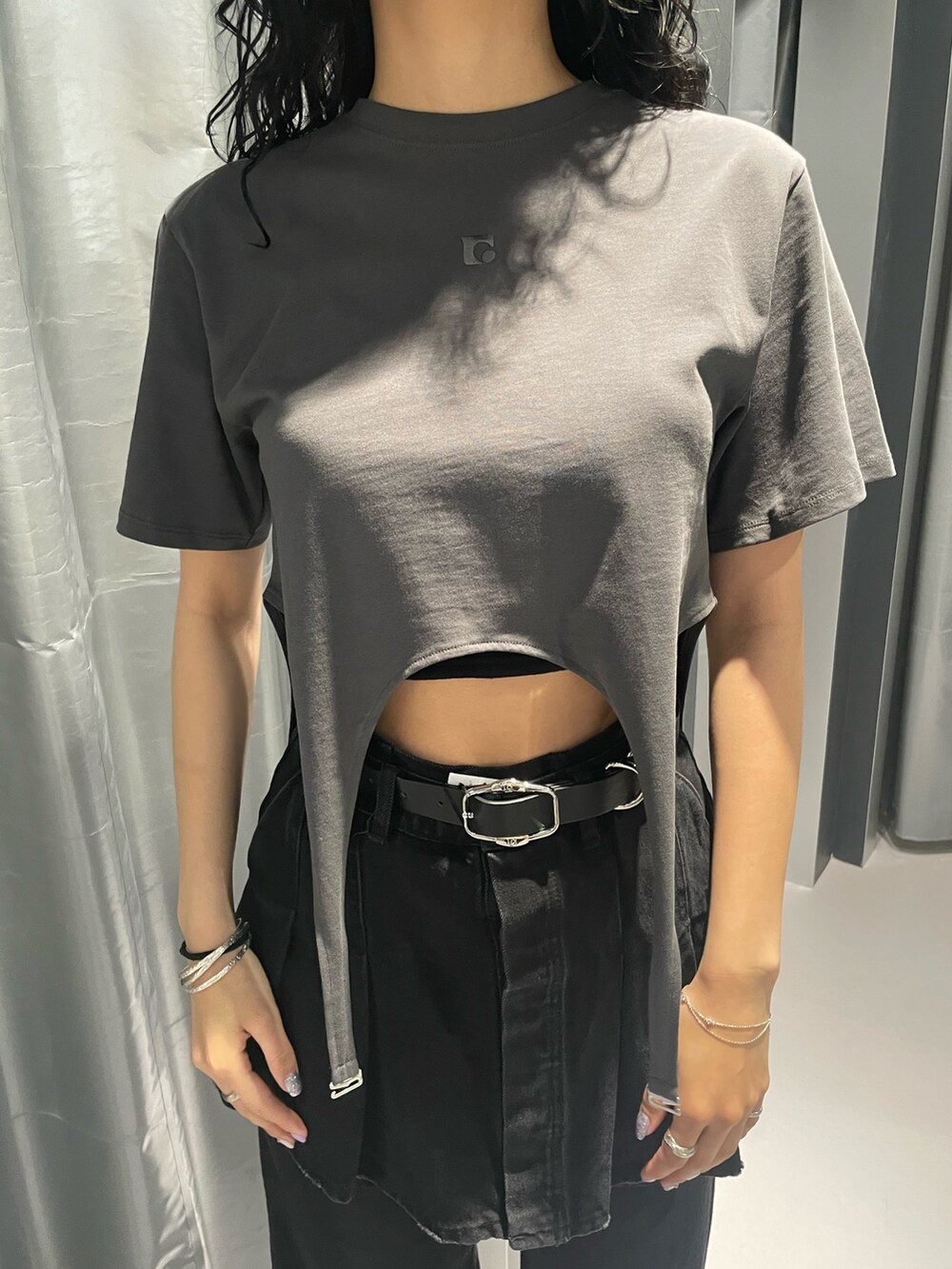 グレー系のTシャツ/カットソー、ブラック系のデニムスカート、ブラック系のデニムパンツを着用したレディースの春コーディネートの4枚目の写真