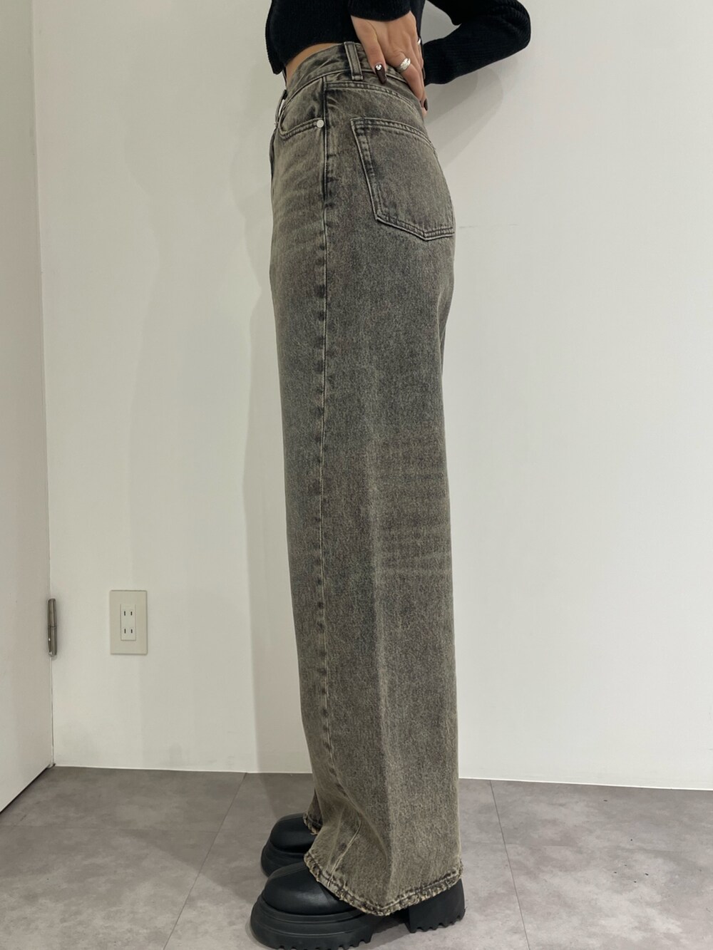 ブラック系のニット/セーター、グレー系のデニムパンツ、ブラック系のブーツを着用したレディースの春コーディネートの8枚目の写真