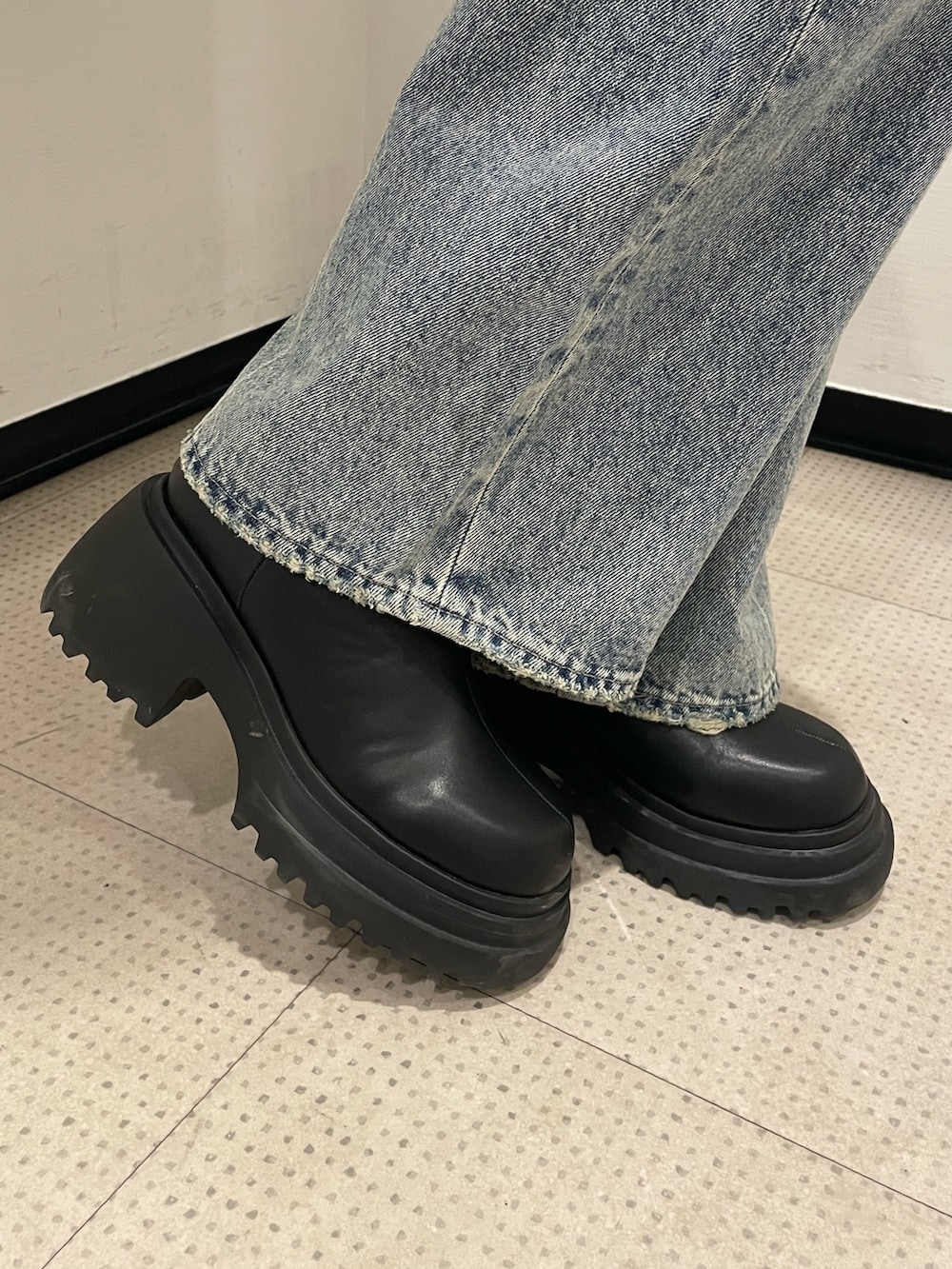 ブラック系のニット/セーター、ブルー系のデニムパンツ、ブラック系のハンドバッグを着用したレディースの冬コーディネートの10枚目の写真