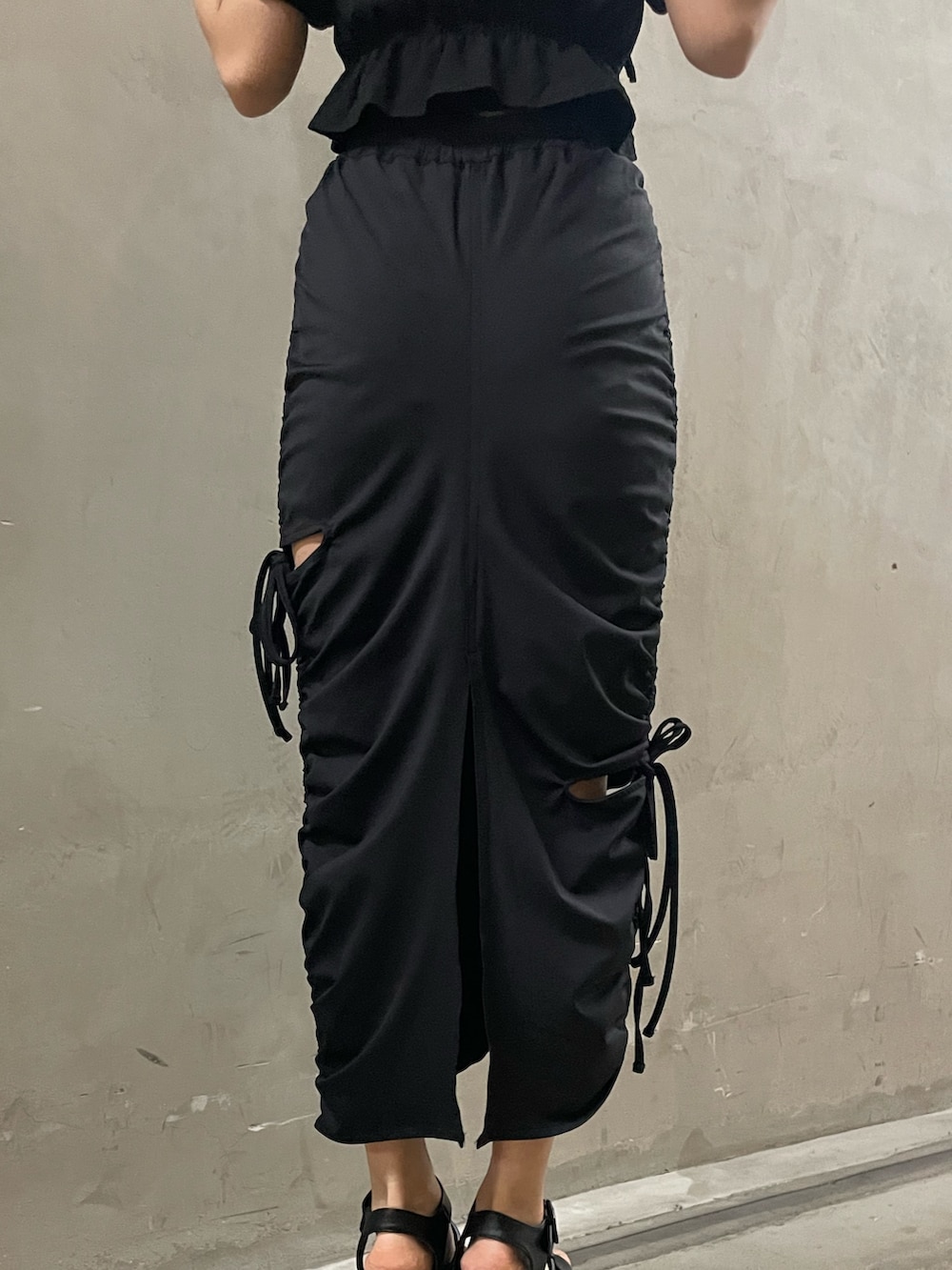 ブラック系のTシャツ/カットソー、ブラック系のスカート、ブラック系のサンダルを着用したレディースの春コーディネートの9枚目の写真