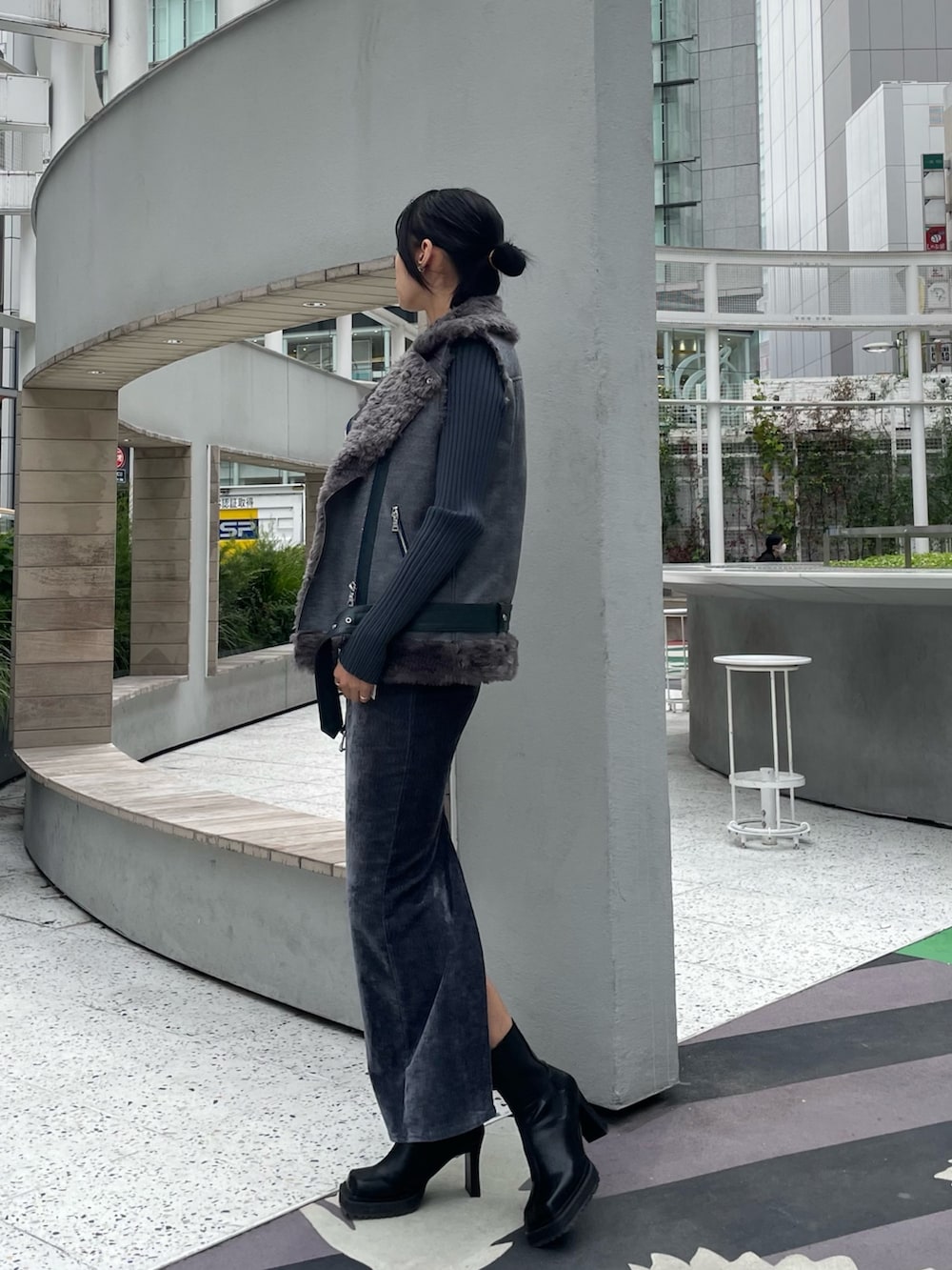 グレー系のベスト、その他のニット/セーター、グレー系のスカートを着用したレディースの秋コーディネートの2枚目の写真