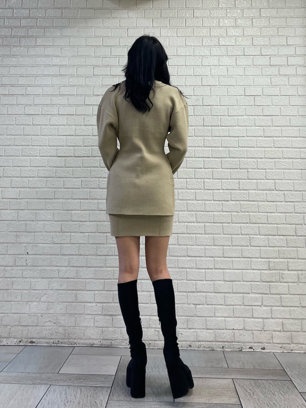 ベージュ系のカーディガン/ボレロ、ベージュ系のスカート、その他のブーツを着用したレディースの秋コーディネートの3枚目の写真