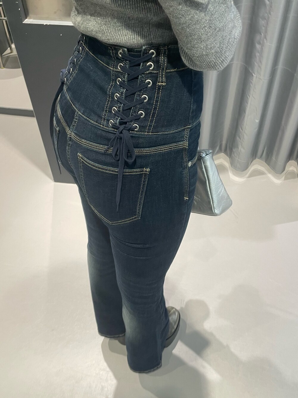 グレー系のニット/セーター、ブルー系のデニムパンツ、シルバー系のショルダーバッグを着用したレディースの冬コーディネートの8枚目の写真