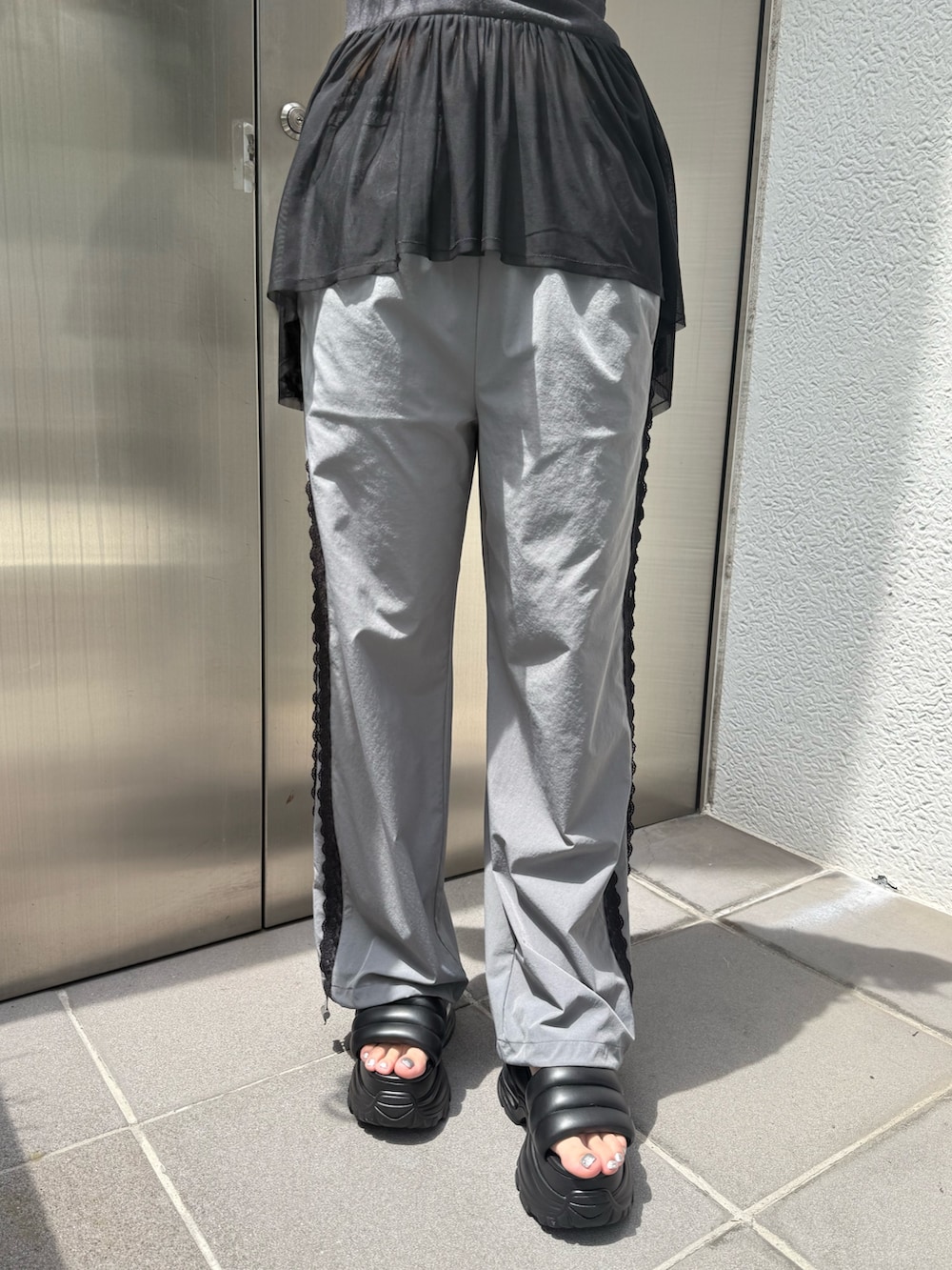 ブラック系のTシャツ/カットソー、ブラック系のハンドバッグ、グレー系のその他パンツを着用したレディースの夏コーディネートの7枚目の写真