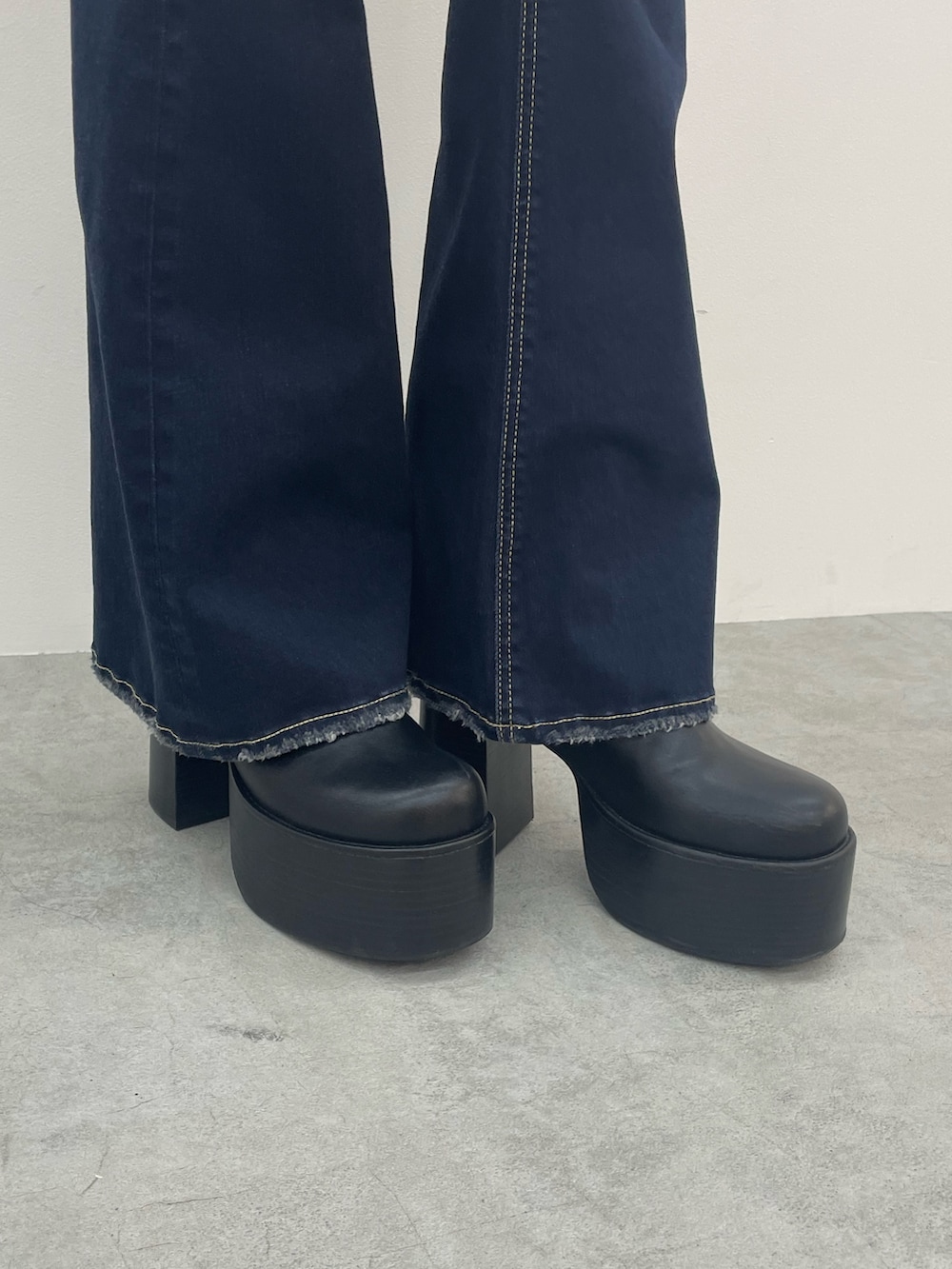 ブルー系のニット/セーター、ブルー系のデニムパンツ、ブラック系のブーツを着用したレディースの夏コーディネートの10枚目の写真