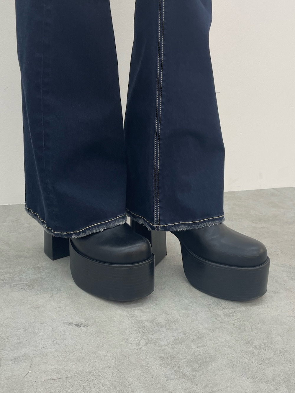 ブルー系のデニムパンツ、ブラック系のブーツ、シルバー系のネックレスを着用したレディースの夏コーディネートの8枚目の写真