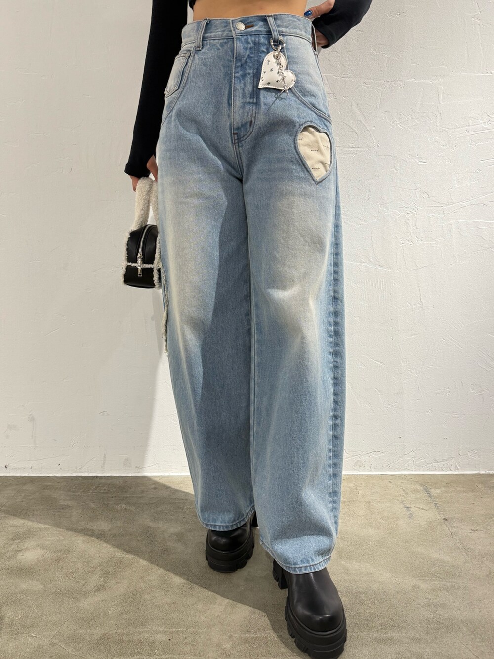 ブラック系のTシャツ/カットソー、ブルー系のデニムパンツ、ブラック系のハンドバッグを着用したレディースの秋コーディネートの5枚目の写真