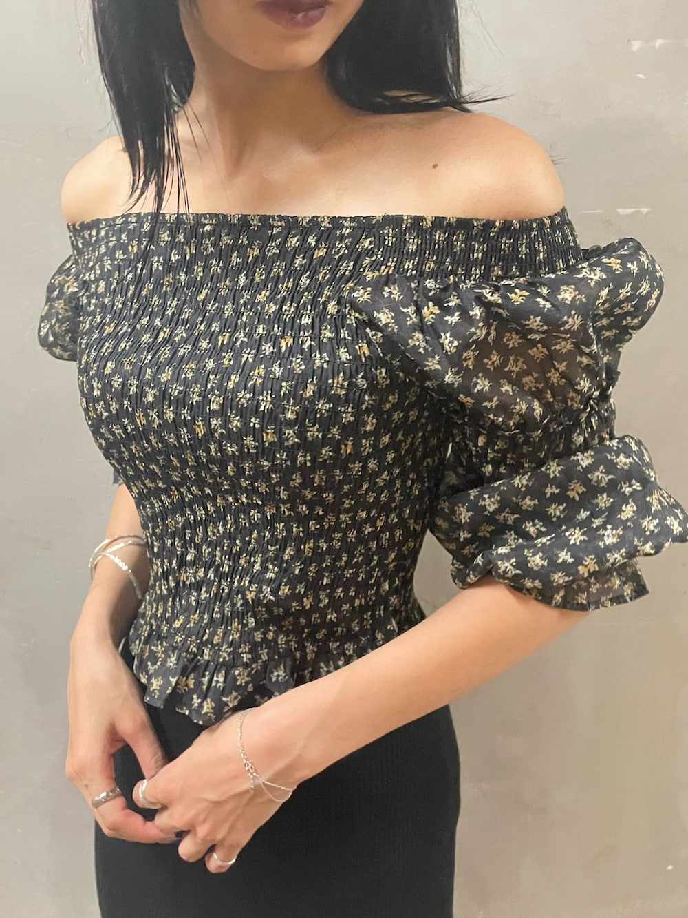 ブラック系のハンドバッグ、ブラック系のスカート、ブラック系のブーツを着用したレディースの秋コーディネートの3枚目の写真