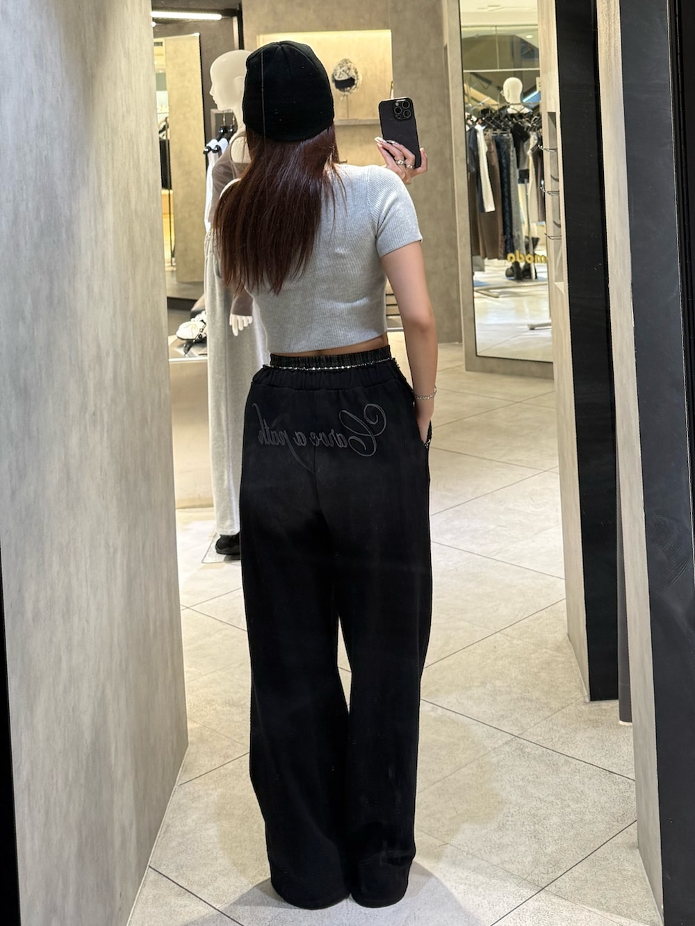 グレー系のニット/セーター、ブラック系のスウェットパンツ、ブラック系のスニーカーを着用したレディースの春コーディネートの3枚目の写真