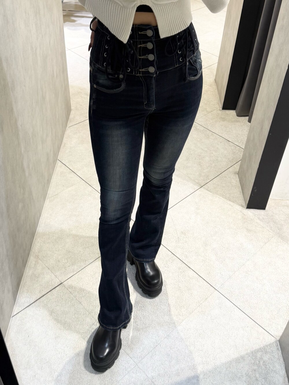 ホワイト系のニット/セーター、ブルー系のデニムパンツ、ブラック系のブーツを着用したレディースの秋コーディネートの6枚目の写真