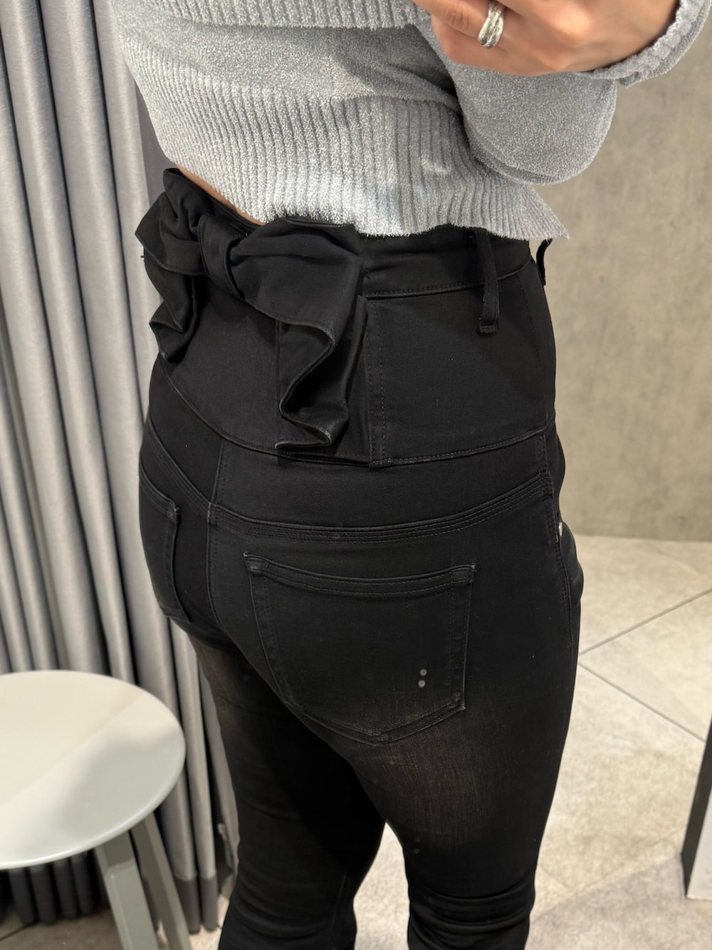 グレー系のニット/セーター、ブラック系のデニムパンツ、ブラック系のブーツを着用したレディースの春コーディネートの7枚目の写真