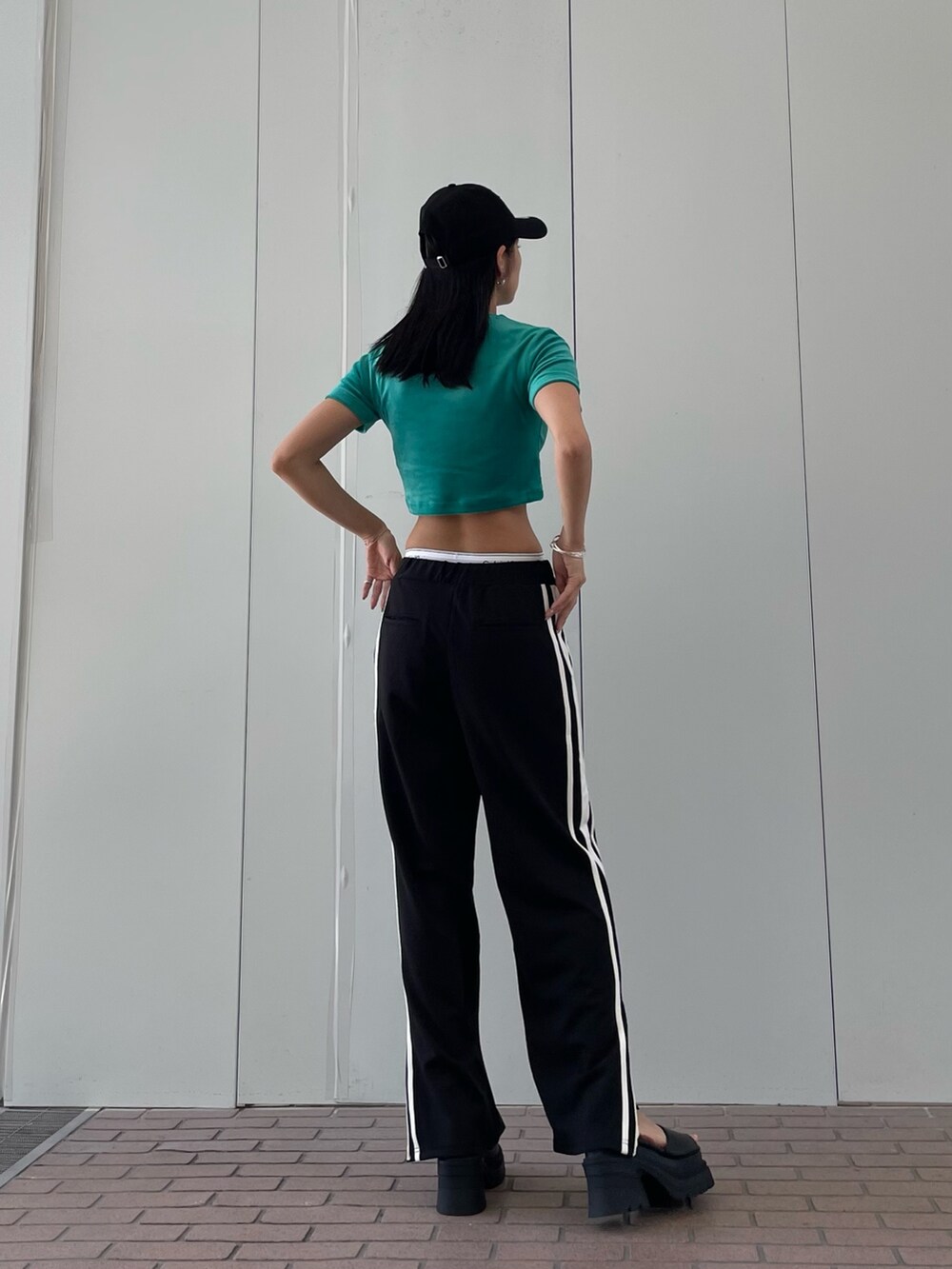 グリーン系のTシャツ/カットソー、ブラック系のその他パンツ、ブラック系のサンダルを着用したレディースの夏コーディネートの9枚目の写真