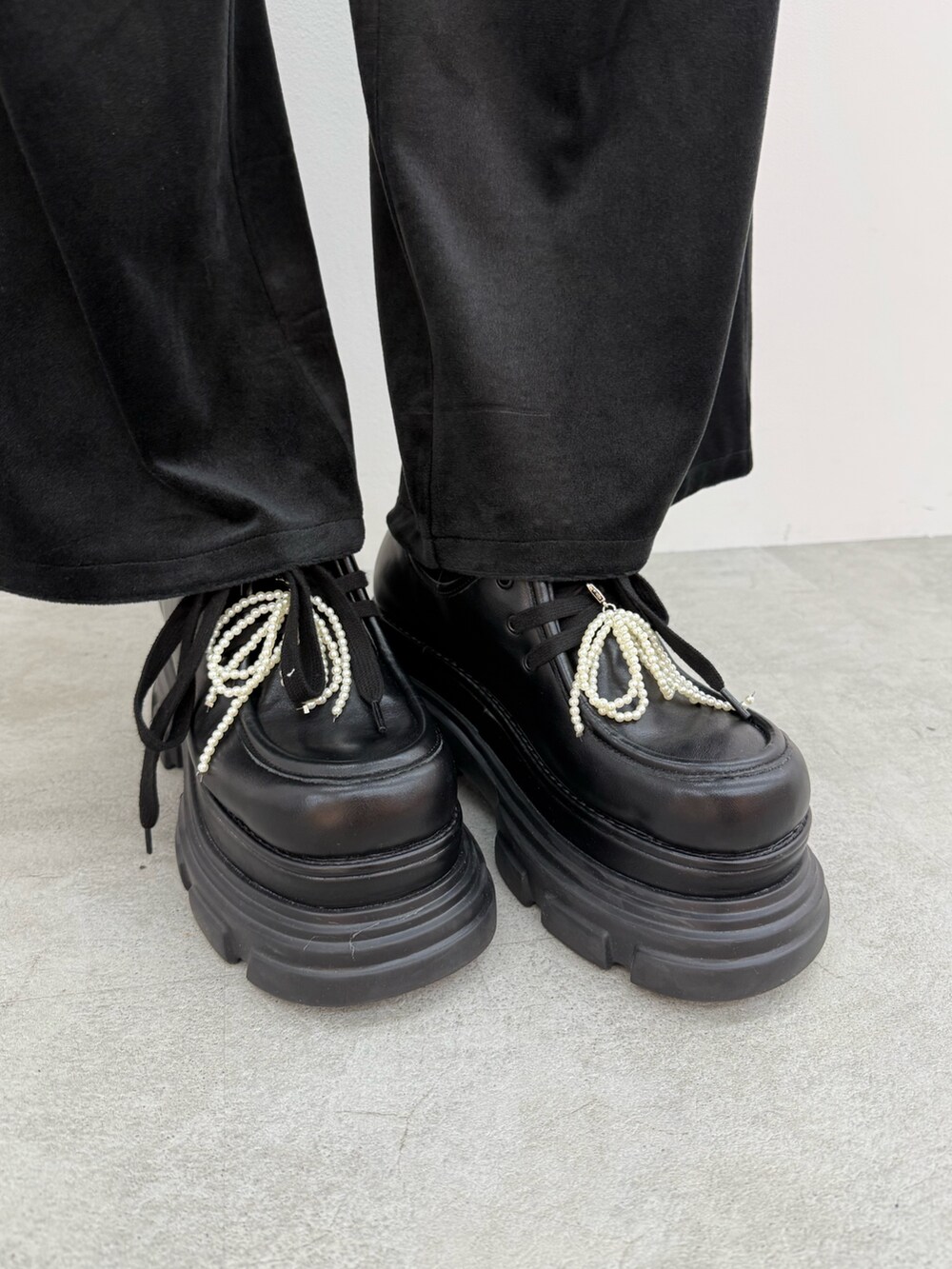 ブラウン系のニット/セーター、ブラック系のその他パンツ、ブラック系のローファーを着用したレディースの夏コーディネートの6枚目の写真